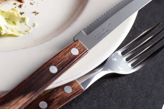 This is an image of a steak knife and fork and both of them have a very beautiful dark wooden handle