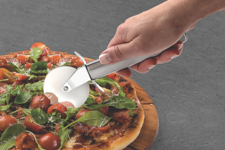 This is an image of a persons hand using a pizza cutter to cut a pizza into slices