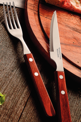 Fork and knife on wooden board