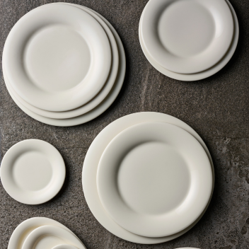 Stacked white plates on surface